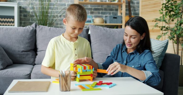 A mother and son enjoying a playful activity at home with bright building blocks.