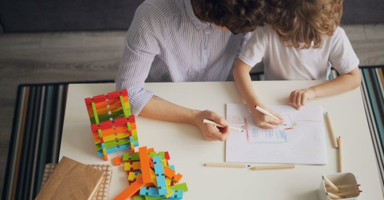 Mi hijo dejó de interesarse por todo: lo que realmente necesitaba 5 A mother and child drawing with colored pencils at a table, fostering creativity and learning.